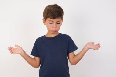 Tereddüt eden, sıradan tişörtler giyen, beyaz arka planda duran, omuz silken, kararsız ve kafası karışık bir çocuk. Cevap yok.