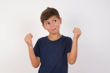 Güzel çocuk günlük tişört giyip izole edilmiş beyaz arka planda duruyor. Elleriyle para hareketi yapıyor. Maaş ödemesi istiyor.