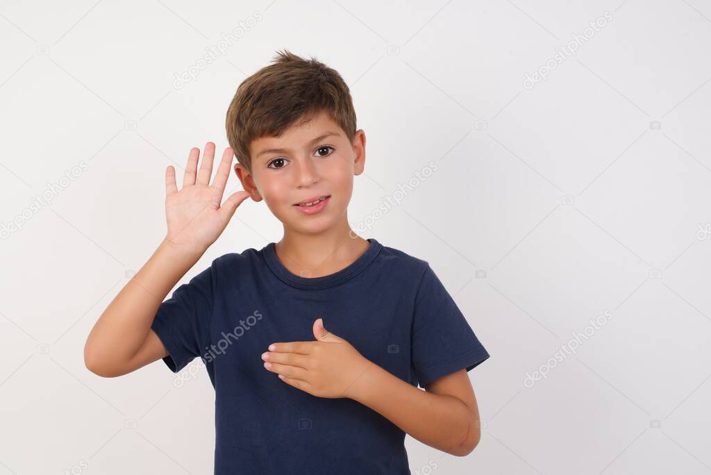 Beautiful kid boy wearing casual t-shirt standing over isolated white background, Swearing with hand on chest and open palm, making a loyalty promise oath
