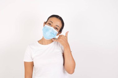 Kısa saçlı, sıradan kırmızı tişörtlü genç yakışıklı adam telefonla el ve parmak hareketleriyle gülümsüyor, telefonda konuşuyor gibi. İletişim kavramları.