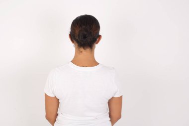 İzole edilmiş beyaz arka planda duran tıbbi maske takan genç bir Arap kadının arka planı. Stüdyo Çekimi.