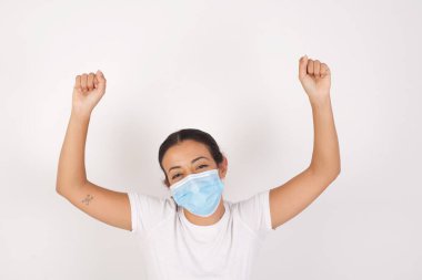 Bağrışmalar, tıbbi maske takan genç Arap kadının izole edilmiş beyaz arka planda ayakta durması, yarışmaları kazanması, satışlarda indirimli malların elleri havada hayrete düşmesi. 