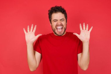 İyimser, mutlu adam kırmızı stüdyoda heyecanlı, kazanan çığlık atıyor. 