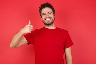 Gülümseyen adam, mutlu bir el hareketi. Kameraya bakıp başarıyı gösteren ifade onaylanıyor