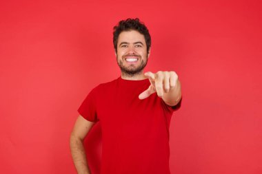 Genç, yakışıklı esmer adam kameraya bakıyor. Tatmin olmuş, kendine güvenen, dost canlısı bir gülümsemeyle. Seni seçiyor. 