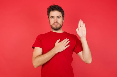 Elleri göğsünde ve elleri açık yemin eden beyaz bir adam sadakat yemini ediyor.