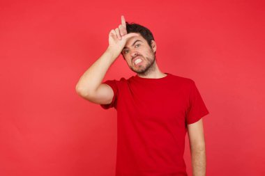 Alnında parmakları olan insanlarla dalga geçen ezik hareketler yapan, alay eden ve aşağılayan bir adam.