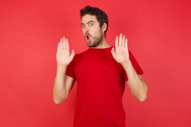 Adam korkuyla ve iğrenç bir ifadeyle reddederek ellerini hareket ettiriyor. Dur ve yasakla.