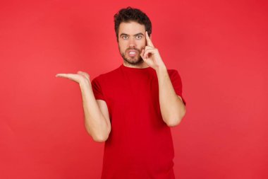 Stüdyodaki adam, elleri fotokopi yeri ve alnını işaret eden eller yüzünden şaşkın ve kızgın. Düşünüyorum. 