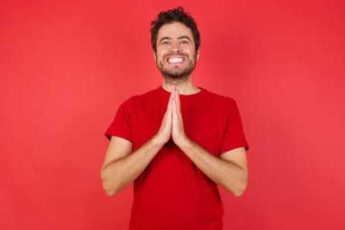 Gülümseyen adam mutlu görünüyor, dua ediyor ve el sallıyor. 