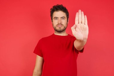 Adam avuç içiyle jesti durduruyor. Yüzünde olumsuz ve ciddi bir jest olan uyarı ifadesi 