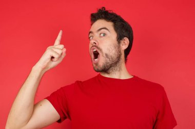 Kırmızı stüdyodaki beyaz adam, başarılı bir fikirle işaret ediyor, heyecanlı ve mutlu, bir numara 