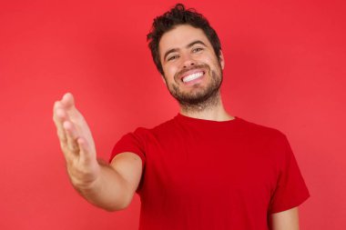 Gülümseyen dost canlısı adam selamlamak ve karşılamak için tokalaşıyor. 