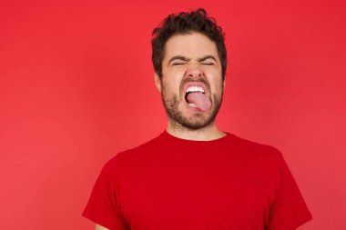 Kızıl stüdyoda genç, beyaz bir adam dil uzatıyordu. 