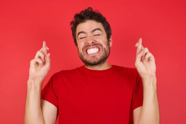 Umut dolu gülümseyen ve gözleri kapalı el sallayan bir adam. Şans ve batıl inançlar. 