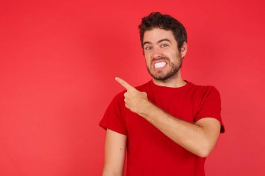 Parmakla işaret eden yakışıklı adam endişeli ve gergin. İşaret parmağı, endişe ve sürpriz konseptiyle.