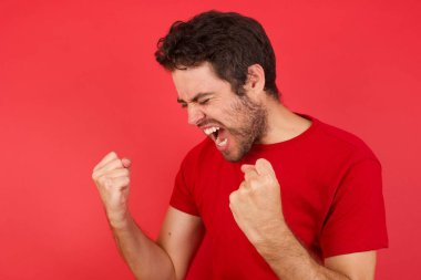 İyimser mutlu adam kırmızı stüdyoda heyecanlı, kazanan duygular 