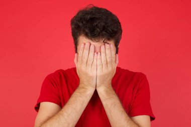 Genç, beyaz bir adam tişört giyip yüzünü elleriyle kapatmış, harap olmuş ve ağlıyormuş. Üzücü bir kavram