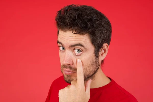 Homem Com Dedo Debaixo Olho Estúdio Vermelho — Fotografia de Stock