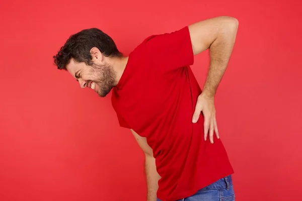 man Suffering of backache, touching back with hand, muscular pain