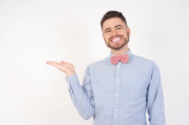 Gülümseyen, neşeli sunum yapan ve avuç içi kameraya bakan adam..