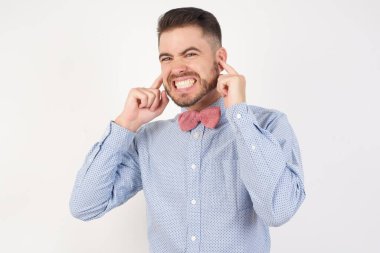 Yüksek sesli müzik sesi için kulakları parmaklarıyla kapatan mutsuz bir adam. Sağır. 