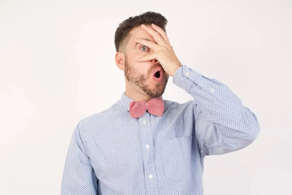 Jovem Caucasiano Espreitando Choque Cobrindo Rosto Olhos Com Mão Olhando — Fotografia de Stock