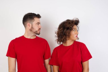 Stüdyodaki adam ve kadın büyüyen duvara bakıyor.