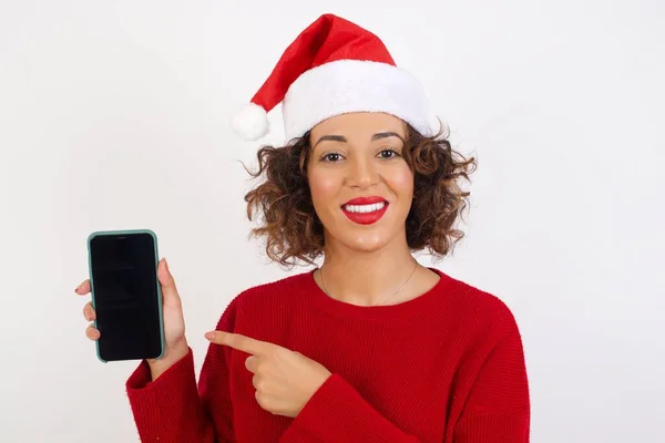 Mulher Papai Noel Chapéu Navegando Telefone Celular Estúdio Sorrindo Apontando — Fotografia de Stock