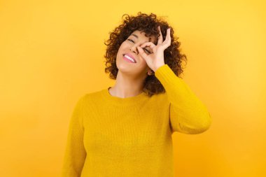 Gülümseyen kadın el hareketleriyle, gözleriyle mutlu yüzüyle parmaklarından bakıyor..