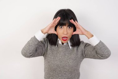 Yüzü korkmuş bir kadın, elleri başının üstünde, çenesi düşmüş, müthiş bir ifadesi var. Omg kavramı