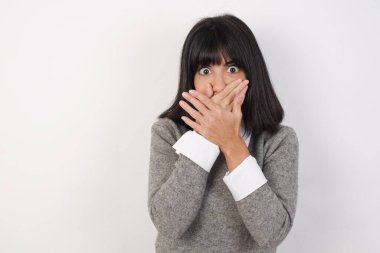 Genç, güzel, esmer kadın yanlışlıkla elleri ile ağzını kapatırken şok oldu. Gizli konsept.