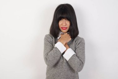 Gri arka planda yalnız başına ağlayan üzgün bir kadının güzel yüzü kederli yüz ifadesi ve duygu konsepti yüzünden acı ve depresyon çeken gözyaşları içinde çaresiz ve depresif bir şekilde.