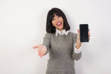 Cep telefonu olan genç beyaz bir kadın. Akıllı telefon sunumu 