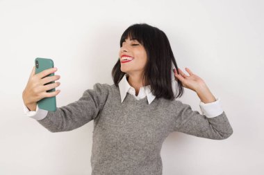 Model gülümsüyor ve kendi sosyal medyasında paylaşmaya hazır bir selfie çekiyor.