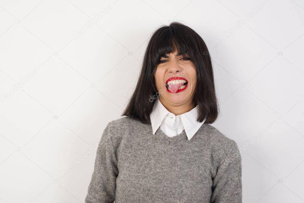 Young caucasian woman sticking tongue out happy with funny expression. Emotion concept.