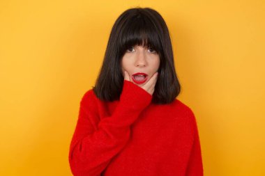 Sarıya boyanmış genç ve güzel bir kadın. İnançsızlıktan, şaşkınlıktan ve elleri çenesinde şaşkınlıktan büyülenmiş bir ifade.