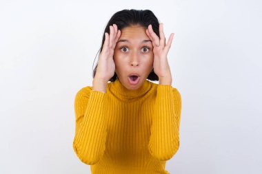 Yüzünde korku ifadesi olan, ellerini başının üstünde tutan, çenesi düşmüş, müthiş bir ifadesi olan bir model. Omg kavramı