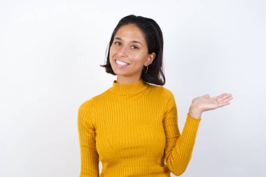 Gülümseyen MODEL sunar ve avuç içi kameraya bakar..