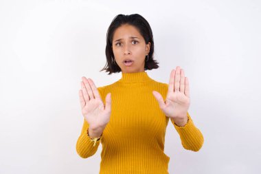 Model, avuç içlerini çekerek korku ve iğrenç bir ifadeyle reddedip inkar ediyor. Dur ve yasakla.