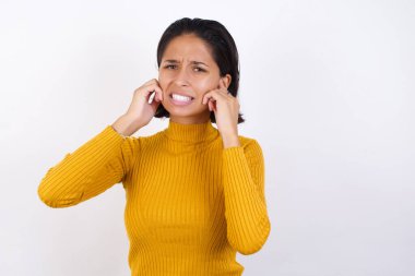 Model, yüksek sesli müzik gürültüsü için kulakları parmaklarıyla kapatıyor. Sağır kavramı.