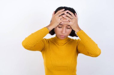 Güzel, genç bir kadın aşırı çalışmaktan dolayı çaresiz ve stresli bir şekilde baş ağrısı çekiyor. Depresyon ve acı kavramı.