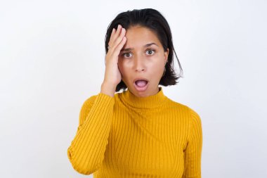 Utanmış genç bir kadın, şok olmuş bir ifadeyle, büyük bir şaşkınlık içinde, Bilmece Adam içeride poz veriyor.