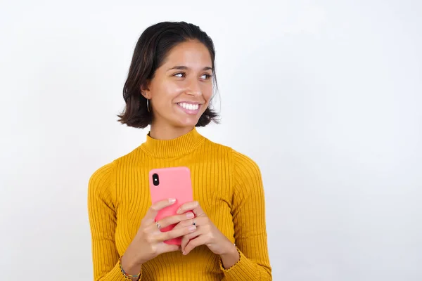 Hermosa Mujer Joven Sosteniendo Teléfono Inteligente Mirando Lado —  Fotos de Stock