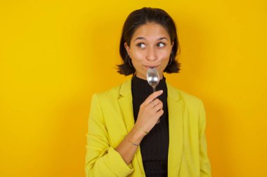 Kaşık tutan çok aç bir manken. Lezzetli bir yemek hayal et.