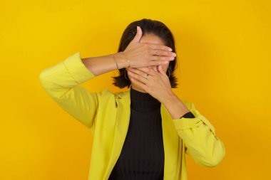 Model gözleri ve ağzı ellerle kaplayan, şaşırmış ve şok olmuş. Duyguları gizlemek.