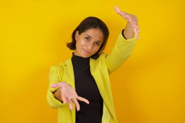  Güzel, genç bir kadın kameraya bakıyor. Sarılmak için kollarını açmış gülümsüyor. Mutluluğu kucaklayan neşeli bir ifade..