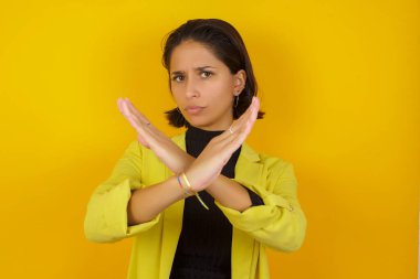  Reddedilmiş güzel genç bir kadın kollarını kavuşturuyor, negatif işaret veriyor, kızgın bir yüz ifadesi takınıyor.