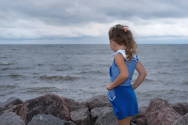 Kind meisje op de zee voor de storm, sterke wind. — Stockfoto