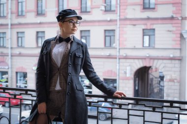 gözlük şık takım elbiseli kız karşı balkonda duruyor